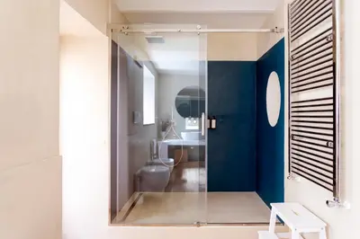 a bathroom with a toilet and a blue wall at Palazzo Castrone, Luxury Apartment in Palermo