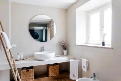 a white bathroom with a sink and a mirror at Palazzo Castrone, Luxury Apartment in Palermo