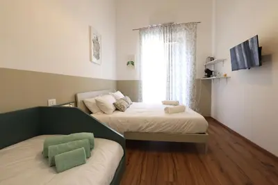 two beds in a small room with a window at Cupola Verde Rooms in Palermo