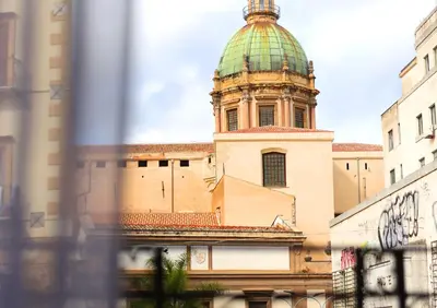 a building with a tower with a green dome at Cupola Verde Rooms in Palermo
