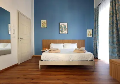 a bedroom with blue walls and a bed with two towels at Cupola Verde Rooms in Palermo