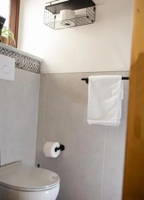 a bathroom with a toilet and a basket of towels at Home Simo al Capo in the old center of Palermo in Palermo