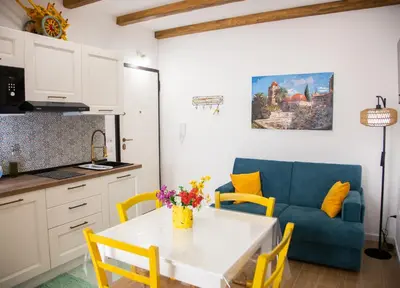 a kitchen and living room with a table and a blue couch at Home Simo al Capo in the old center of Palermo in Palermo