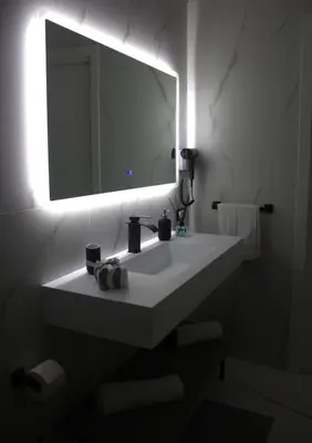 a bathroom with a white sink and a mirror at Sikelia House - Comfort Apartment in Palermo