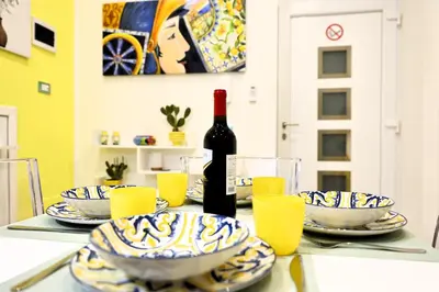 a bottle of wine sitting on a table with glasses at Sikelia House - Comfort Apartment in Palermo