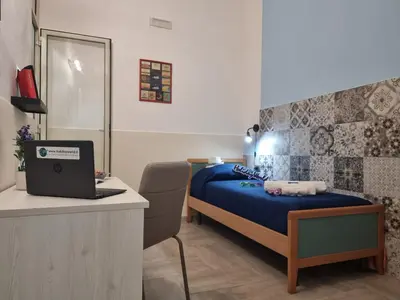 a bedroom with a bed and a desk with a laptop at Casa Vulpi by Holiday World in Palermo