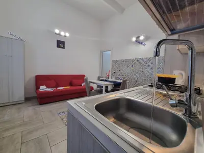 a kitchen with a sink and a red couch at Casa Vulpi by Holiday World in Palermo