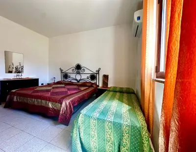 a bedroom with a bed and a window at Casa del Sole in Campofelice di Roccella
