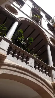a building with a balcony with plants on it at Cortile Galletti - Cool Flat with Private Courtyard in Palermo