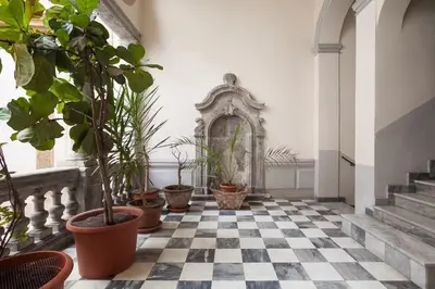 a room with potted plants on a checkered floor at Cortile Galletti - Cool Flat with Private Courtyard in Palermo