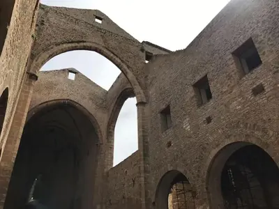 an old brick building with two arches on it at Cortile Galletti - Cool Flat with Private Courtyard in Palermo