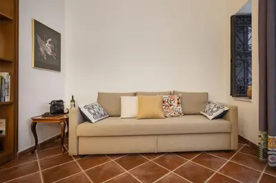 a living room with a couch with pillows on it at Cortile Galletti - Cool Flat with Private Courtyard in Palermo