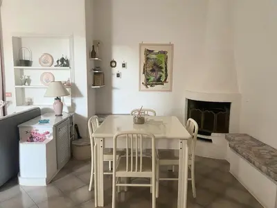 a dining room with a table and chairs and a fireplace at Villa Glicine a pochi passi dal mare e dal centro in San Vito lo Capo
