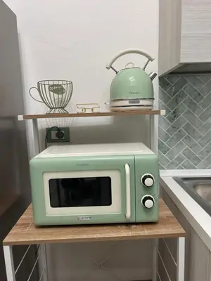 a green microwave on a shelf in a kitchen at Coco Memi Apartment in Palermo