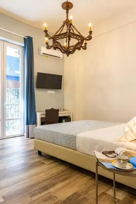 a bedroom with a bed and a chandelier at Pagano Home Guesthouse in Palermo