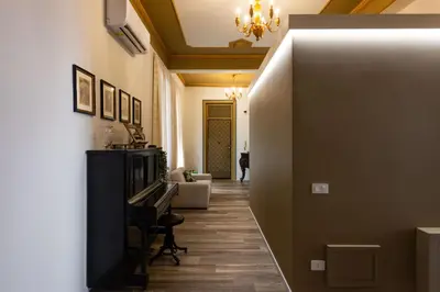 a hallway with a piano and a living room at Pagano Home Guesthouse in Palermo