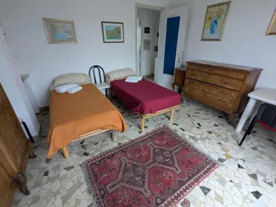 a room with two beds and a dresser and a rug at Montesanto in Palermo