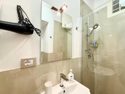 a bathroom with a shower and a sink and a mirror at Vicolo Giardi in Palermo