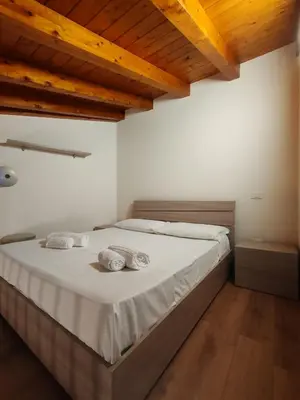 a bedroom with a bed with white sheets and wooden ceilings at A fera vecchia by Casa Azzurra Apartments in Palermo