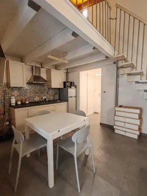 a kitchen with a table and chairs and a staircase at A fera vecchia by Casa Azzurra Apartments in Palermo