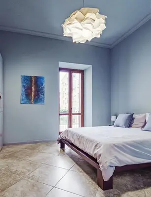 a bedroom with a large bed and a chandelier at BallarHòme 105 