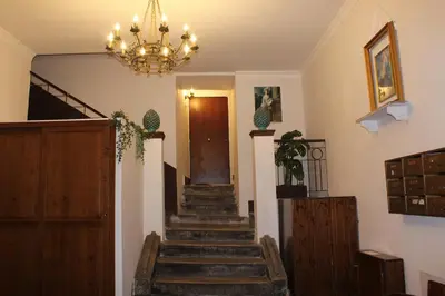 a hallway with stairs with a chandelier and a door at Giacalone15 - EXCLUSIVE APARTMENT IN THE HISTORIC CENTER NEAR THE TEATRO MASSIMO in Palermo