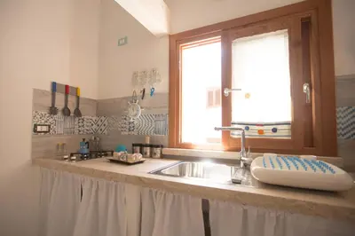 a kitchen counter with a sink and a window at La Casetta nel Porto in Castellammare del Golfo