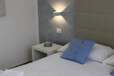 a bedroom with a bed with a blue pillow on it at B&B Selene in San Vito lo Capo