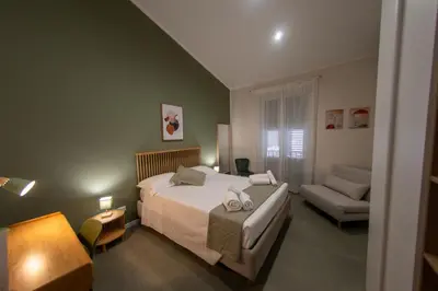 a bedroom with a large bed and a couch at A casa da Carlo al Borgo 2 in Palermo