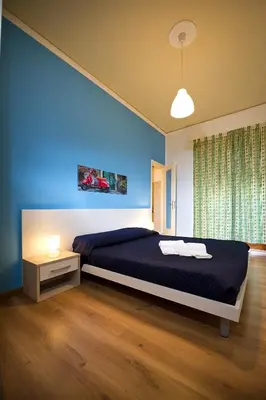 a bedroom with a bed and a blue wall at Affittacamere le scale in Castellammare del Golfo