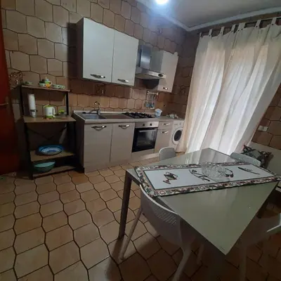a small kitchen with a table and a counter top at Rossy guest house 3 in Isola delle Femmine