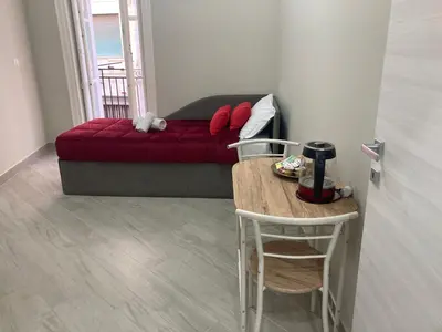 a living room with a red couch and a table at Isti e Binisti Flat in Palermo