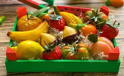 a green box filled with fruits and vegetables on a table at Kalaciuri Rooms in Palermo