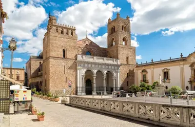 a large stone building with a tower and a bridge at Kalaciuri Rooms in Palermo