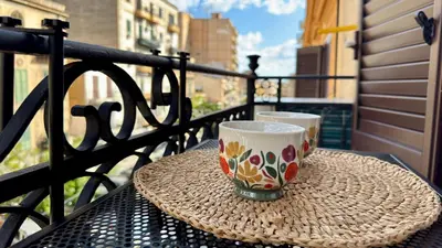 two cups sitting on a table on a balcony at SulCorsoRooms in Palermo