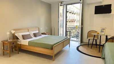 a bedroom with a bed and a balcony at SulCorsoRooms in Palermo