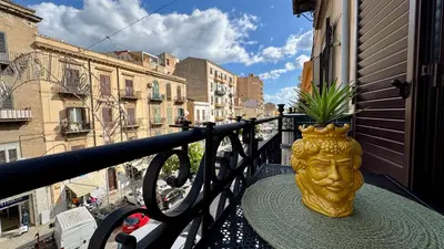 a gold vase sitting on a table on a balcony at SulCorsoRooms in Palermo