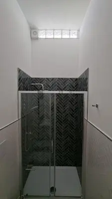 a shower with a glass door in a bathroom at Casetta Giardinetto in Altavilla Milicia