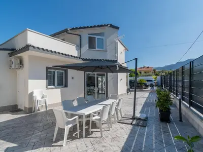 a table and chairs with an umbrella on a patio at Luxury Villa Sicula Trabia in Trabia