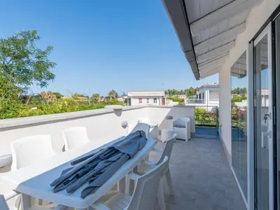 a white table and chairs on the balcony of a house at Luxury Villa Sicula Trabia in Trabia