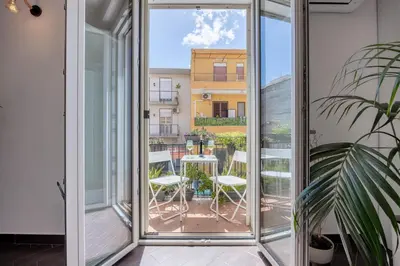 a glass door leading to a balcony with a table and chairs at Mama apt - Comfort & style in Partanna Mondello in Palermo