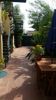a patio with tables and an umbrella and plants at Apartment in Villa a Mondello in Mondello