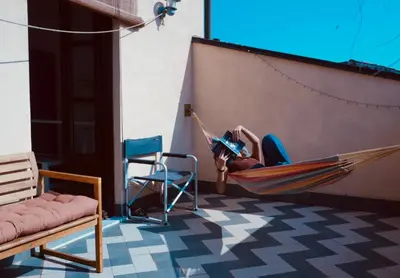 a person laying in a hammock in a room at Epic terrace in Kalsa in Palermo
