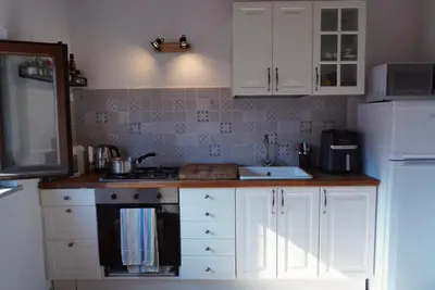 a kitchen with white cabinets and a stove and a sink at Epic terrace in Kalsa in Palermo