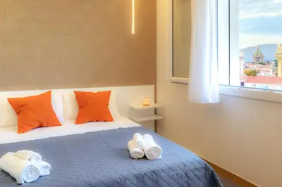 a bedroom with a bed with orange pillows and a window at Valenza Exclusive Suites & Rooms in Palermo