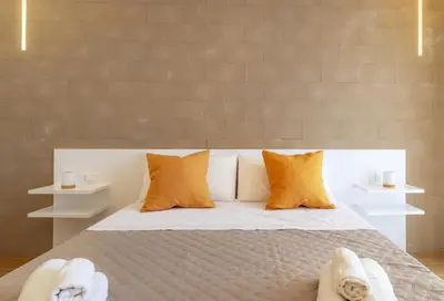 a bedroom with a bed with white and orange pillows at Valenza Exclusive Suites & Rooms in Palermo