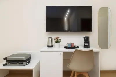 a desk with a chair and a television on a wall at Valenza Exclusive Suites & Rooms in Palermo