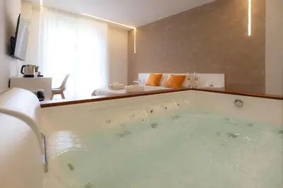 a large bath tub in a room with a bedroom at Valenza Exclusive Suites & Rooms in Palermo