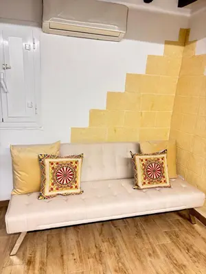 a white couch with pillows in a room with stairs at Dimora Albanese in Palermo