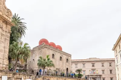 an old building with palm trees in front of it at Bellini Apartment by Wonderful Italy in Palermo